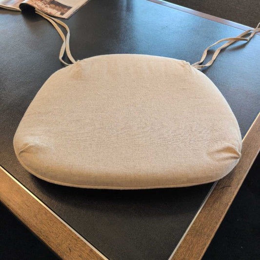 Beige seat cushion on a chair with a dark surface