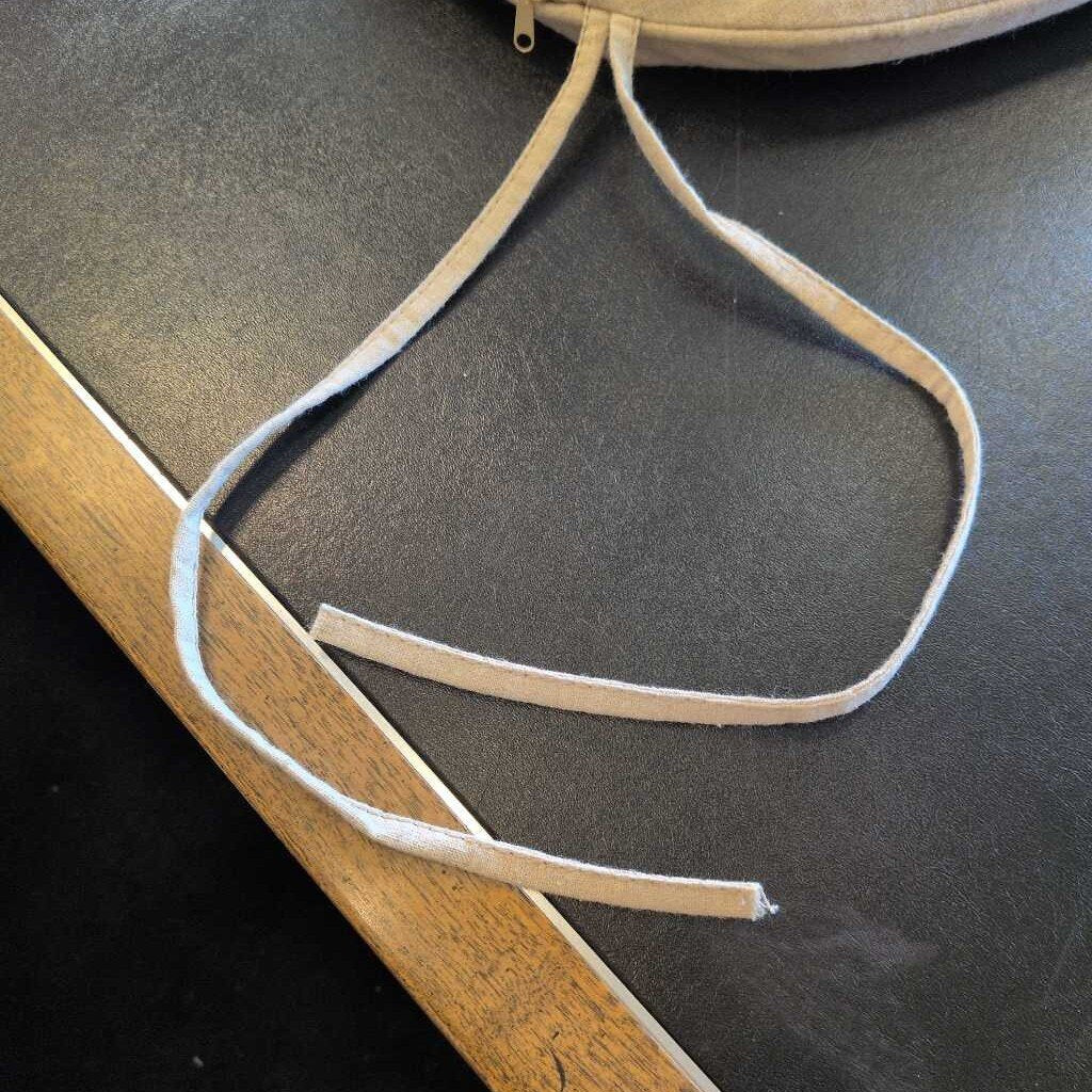 Close-up of a beige leather strap on a dark surface