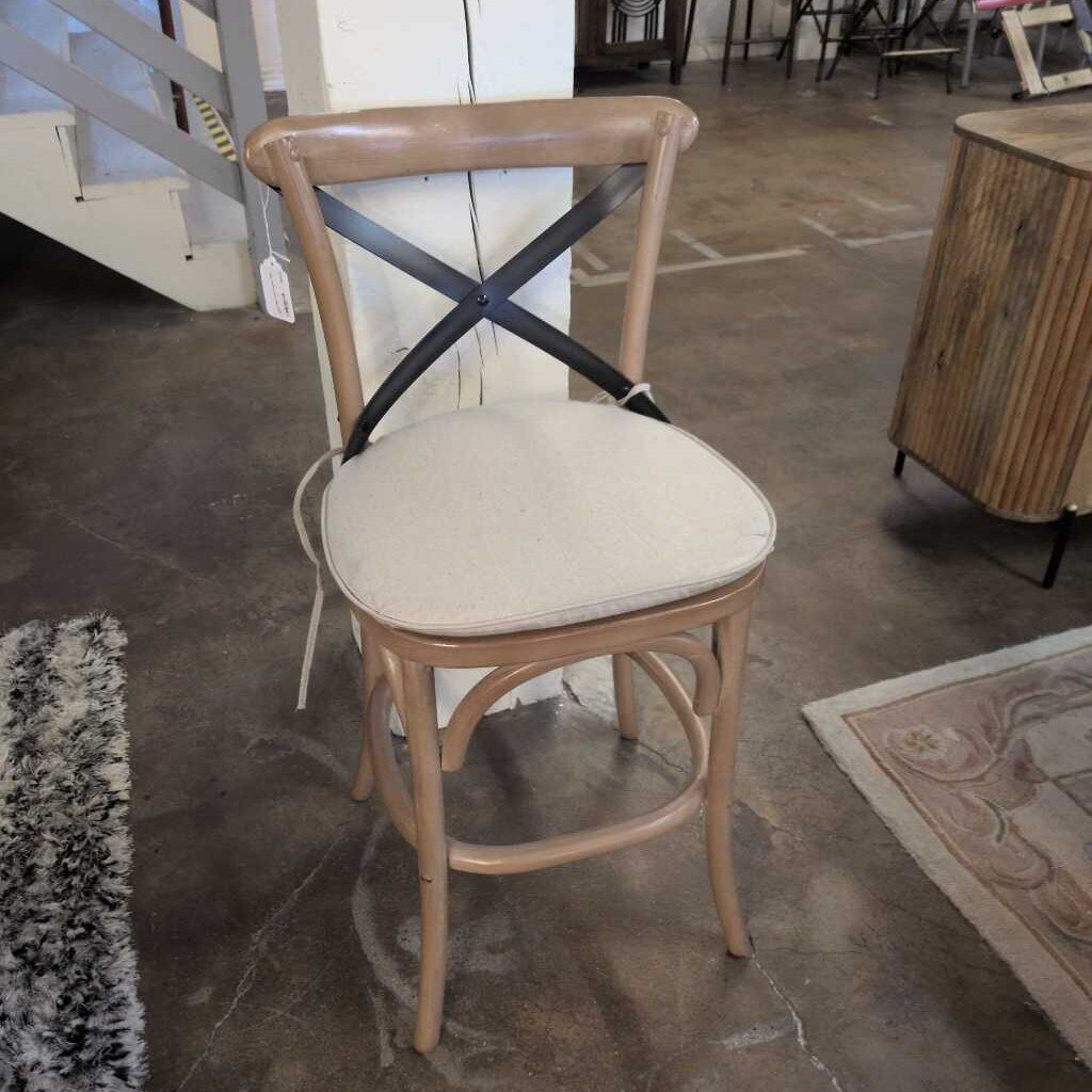 Chair with beige cushion on a concrete floor in an indoor setting