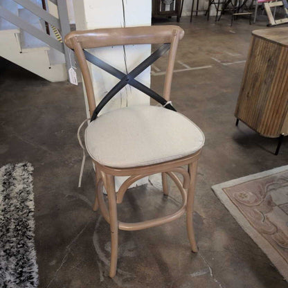 Chair with beige cushion on a concrete floor in an indoor setting