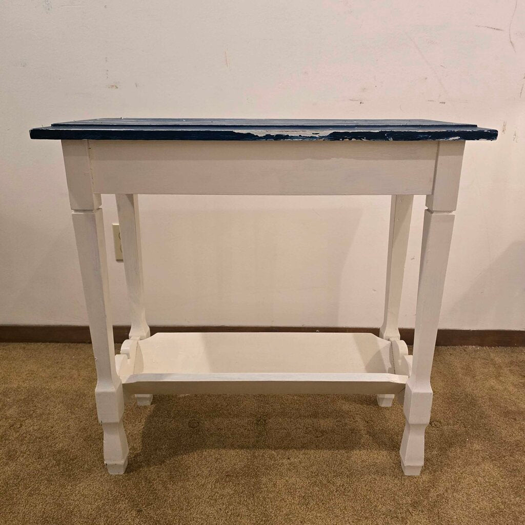 White table with a blue top against a plain wall.