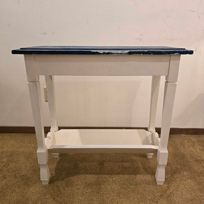 White table with a blue top against a plain wall.