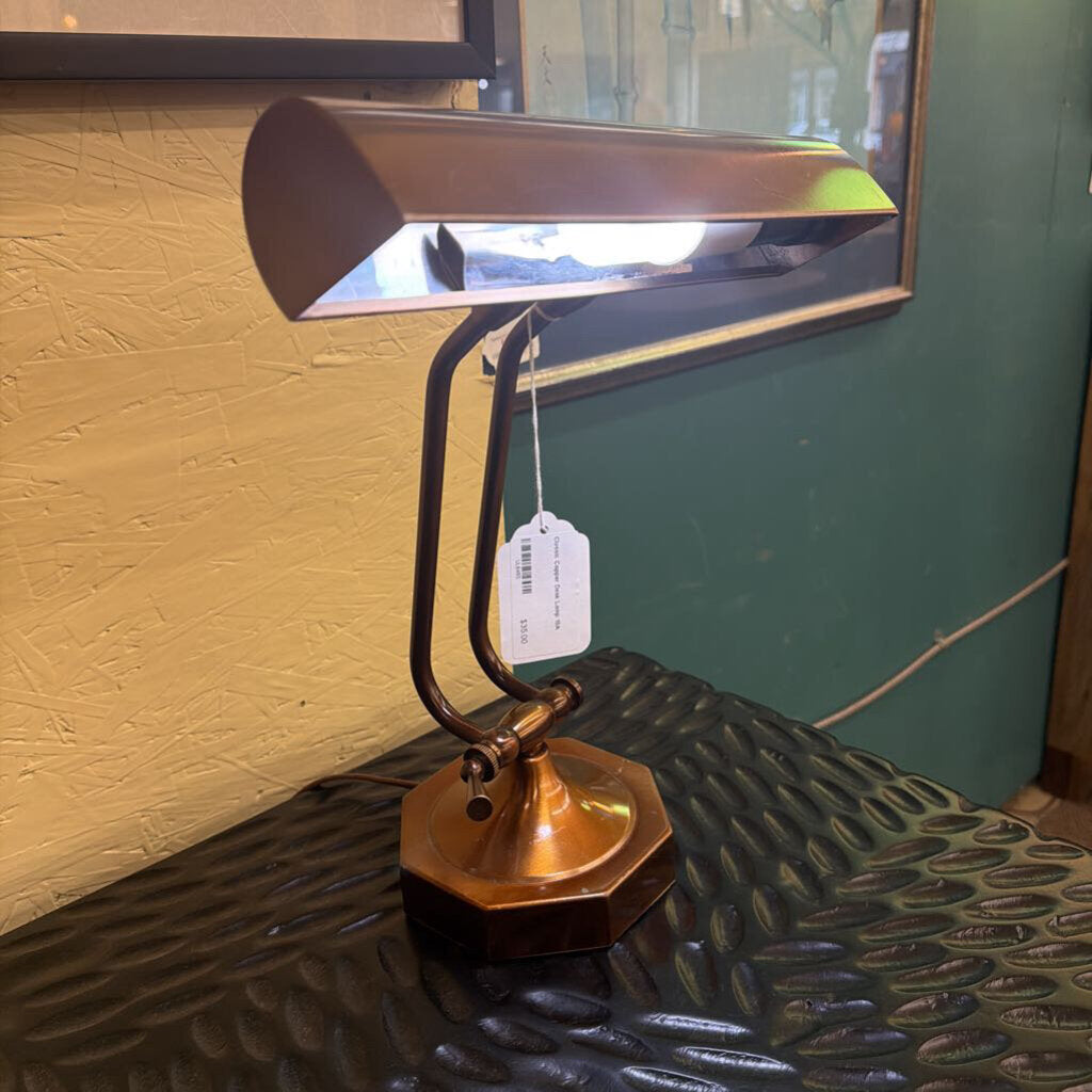 Vintage-style desk lamp on a textured surface with a yellow wall in the background