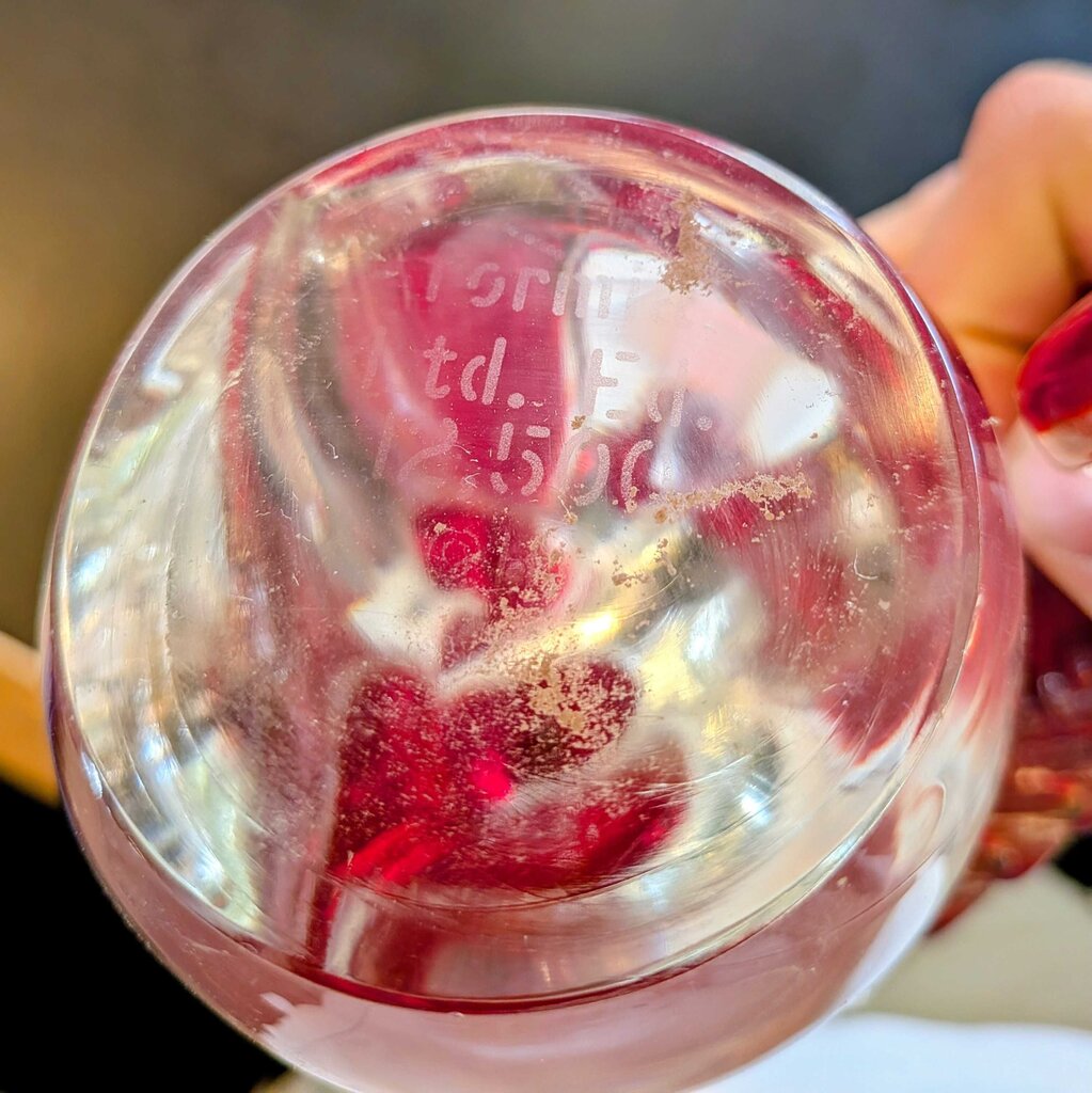 Clear gelatin dessert with red jelly inside, held by a hand.