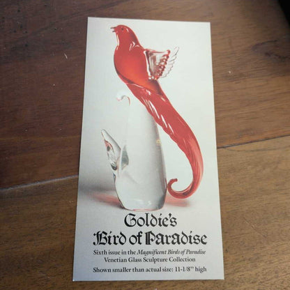 Brochure for Goldie's Bird of Paradise sculpture on a wooden surface
