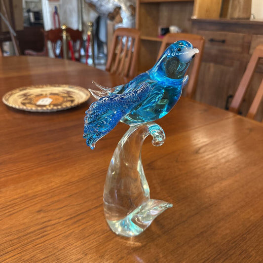 Blue glass bird figurine on a wooden table
