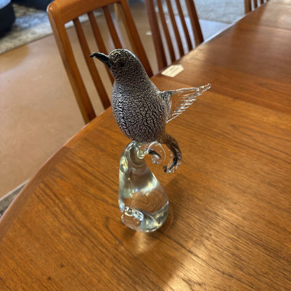 Glass bird figurine on a wooden table
