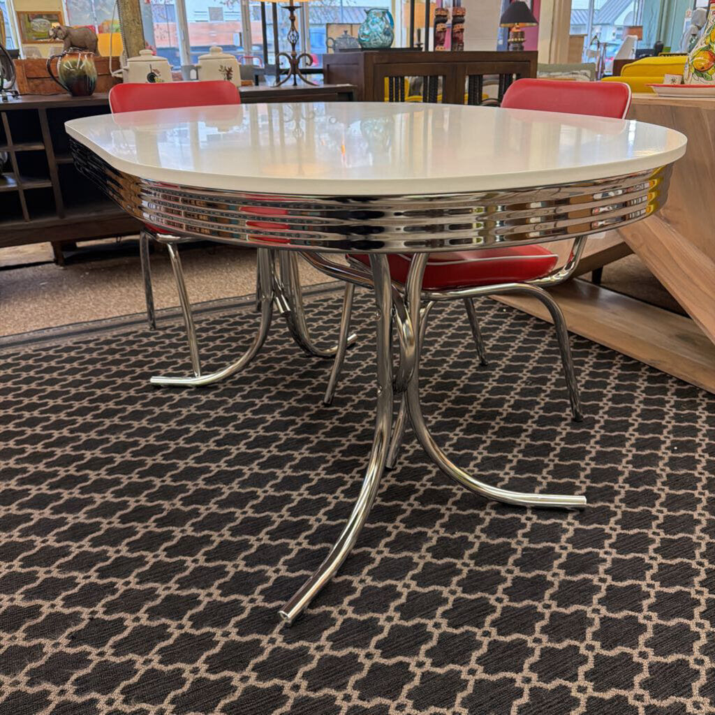 Diner-style table with red chairs on a patterned carpet