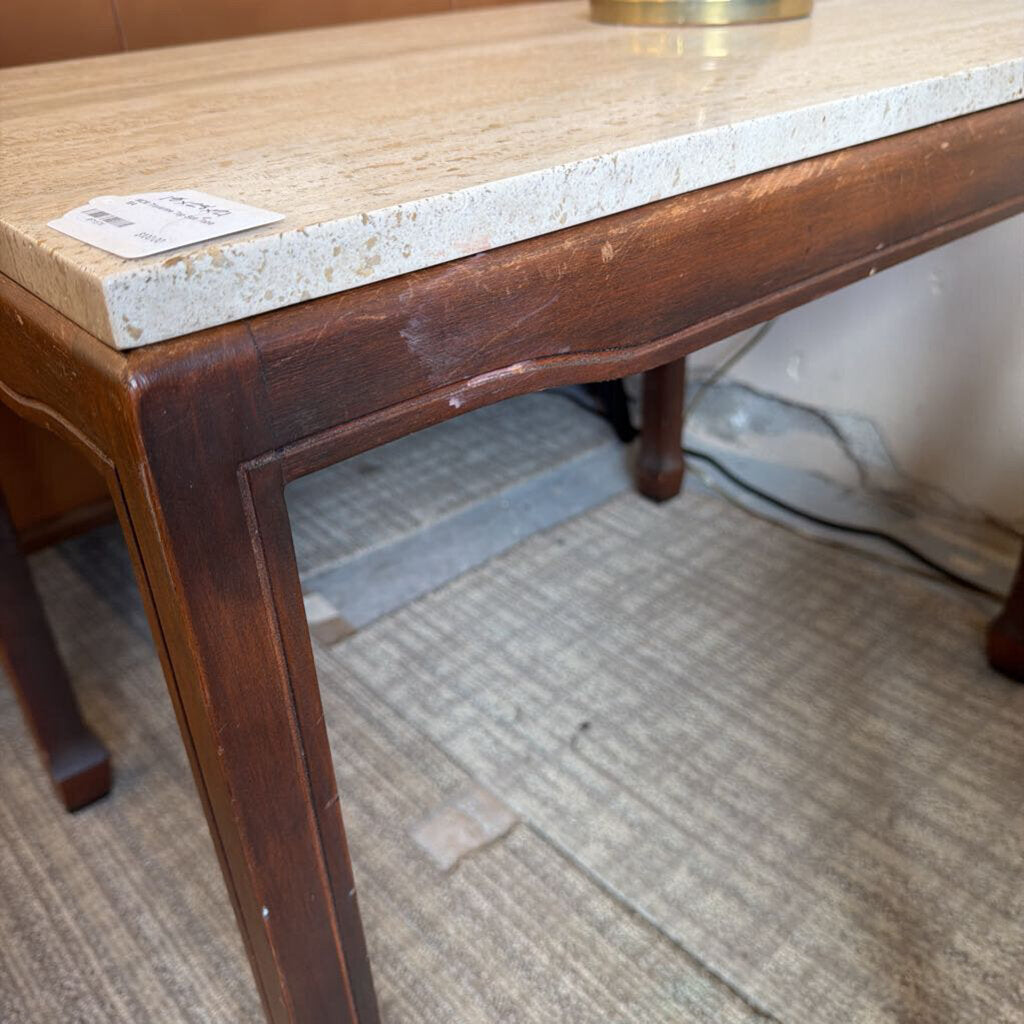 Wooden table with marble top on a carpeted floor