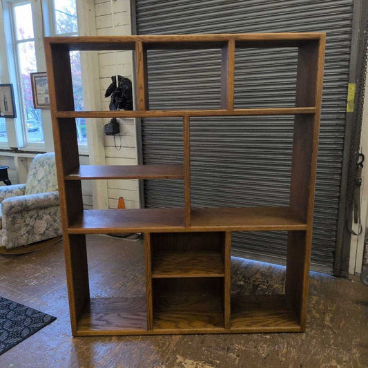 Wooden bookshelf in a room with a window and furniture.