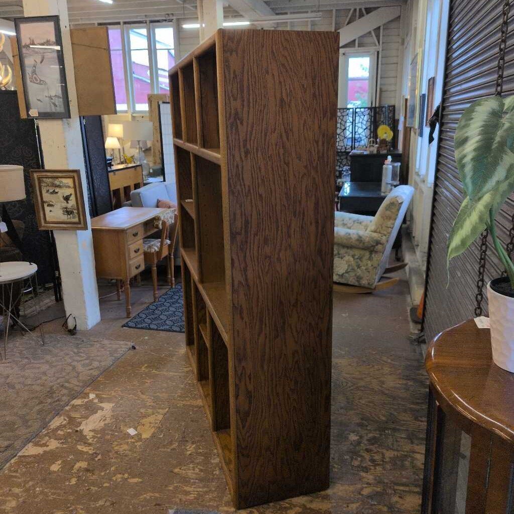 Tall wooden bookshelf in a room with furniture and decor