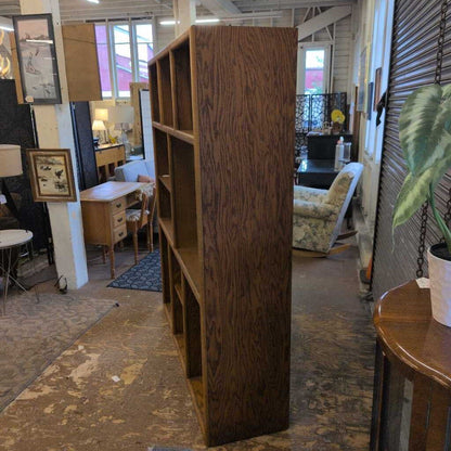 Tall wooden bookshelf in a room with furniture and decor
