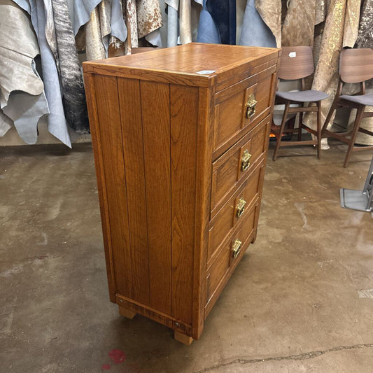 Wooden dresser with multiple drawers in a storage or warehouse setting.
