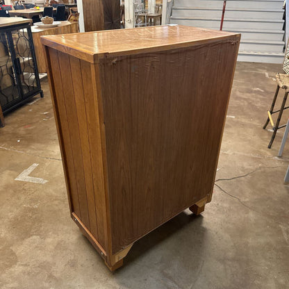 Wooden bar or counter on a concrete floor with chairs and tables in the background