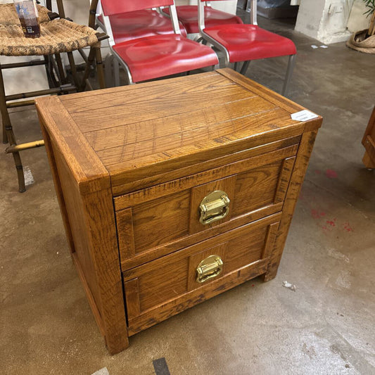 Wooden nightstand with two drawers in a storage or warehouse setting