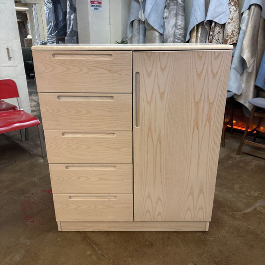 Wooden cabinet with drawers and a door in an indoor setting