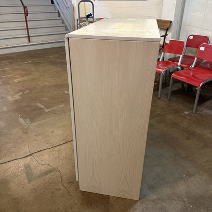 Wooden podium with a white top in an indoor setting with red chairs and a staircase.