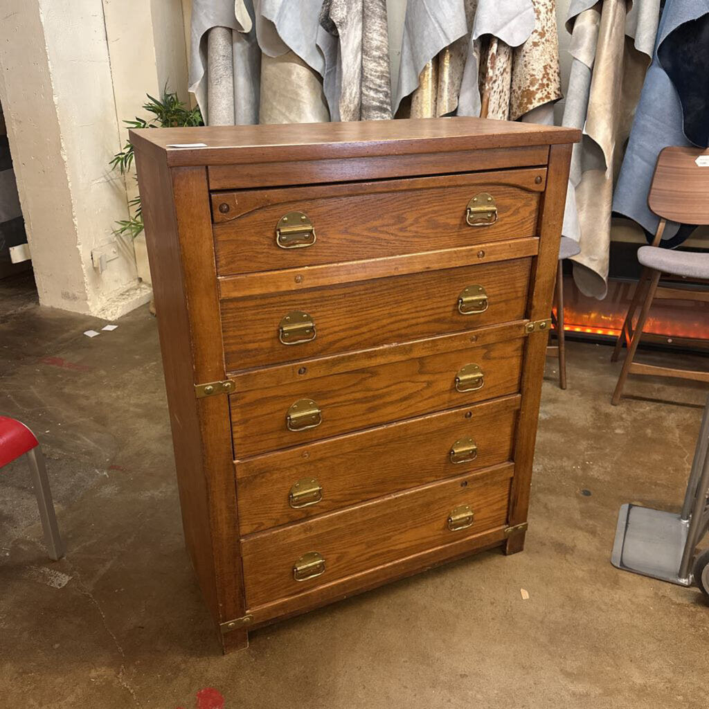 Wooden dresser with brass handles in a room setting