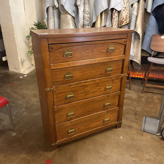 Wooden dresser with brass handles in a room setting