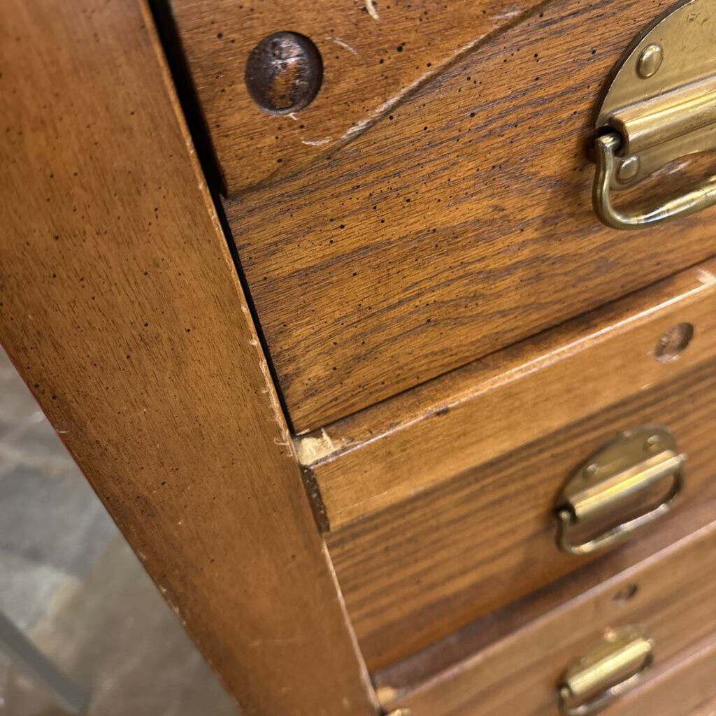 Close-up of a wooden drawer unit with brass handles and latches.