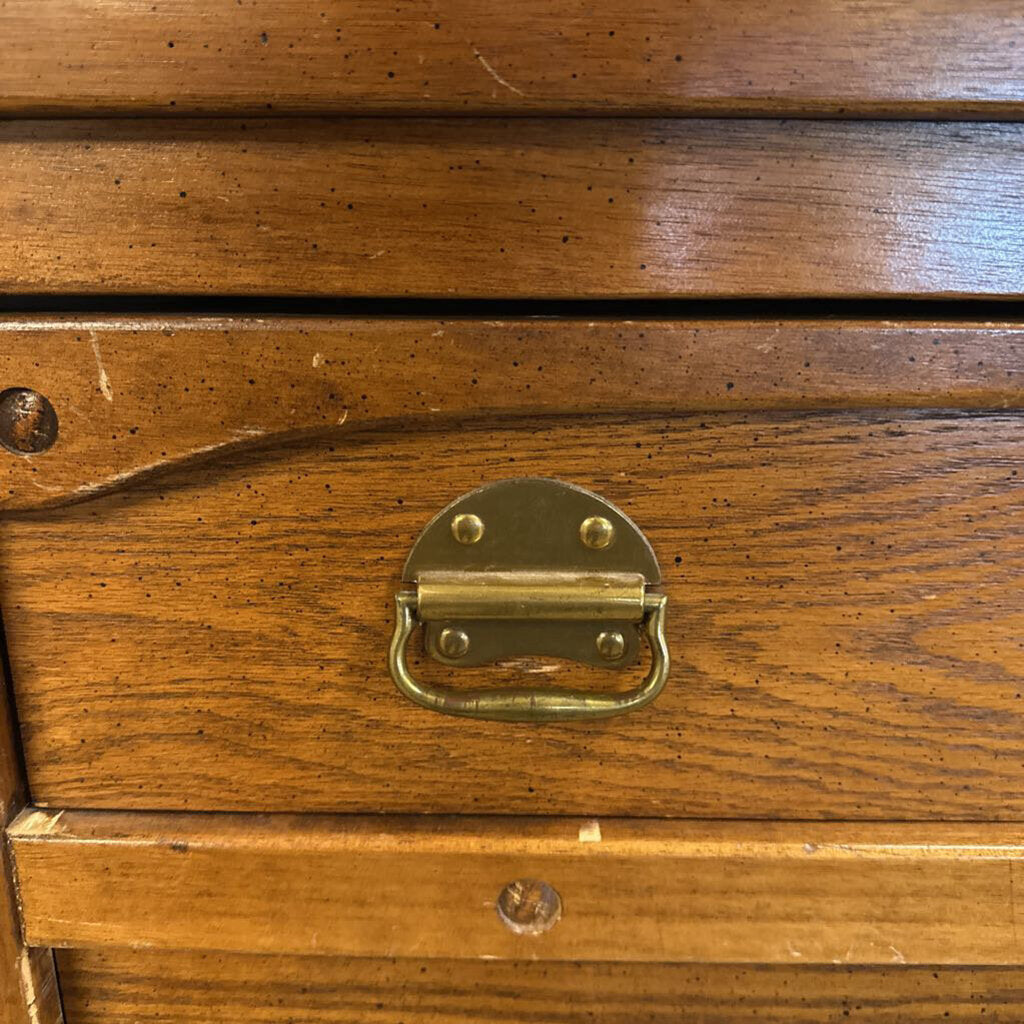 Close-up of a wooden drawer with a brass handle