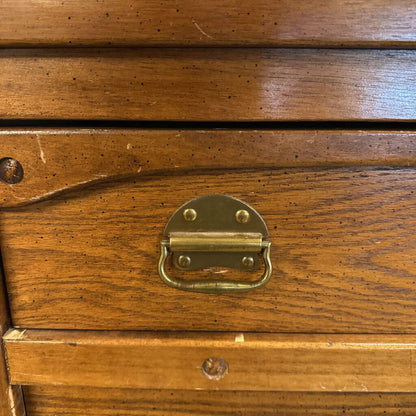 Close-up of a wooden drawer with a brass handle