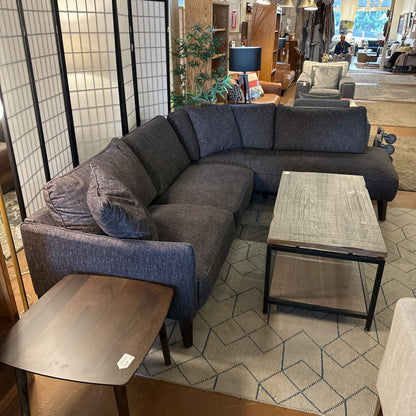 Gray sectional sofa in a room with a coffee table and decorative items.