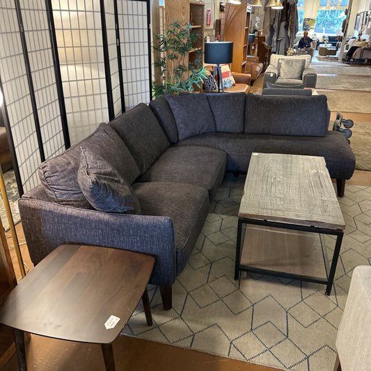 Gray sectional sofa in a room with a coffee table and decorative items.