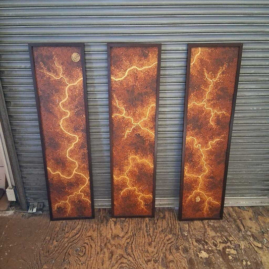 Three vertical panels with a rust-like design against a metal shutter background.