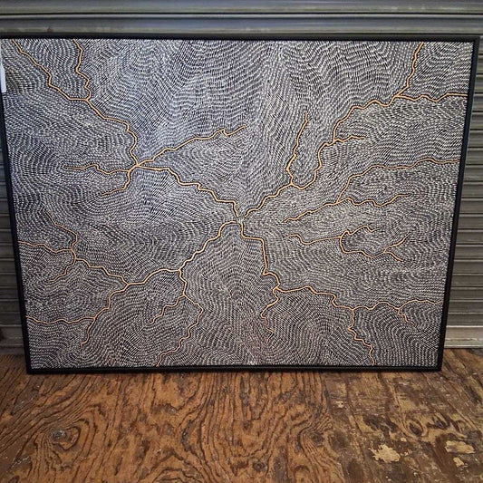 Framed abstract artwork with wavy lines on a wooden floor