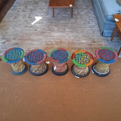 Colorful woven stools on a wooden floor with furniture in the background