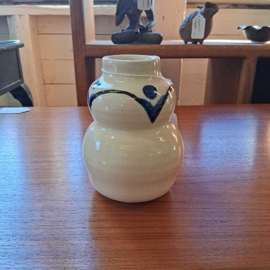 White ceramic jar with blue design on a wooden table