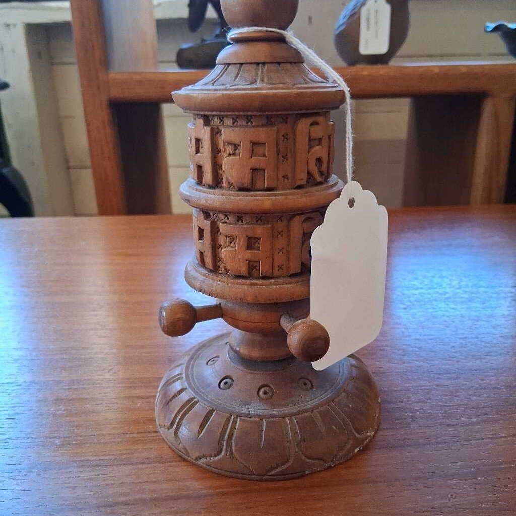Wooden decorative item with intricate carvings on a wooden table