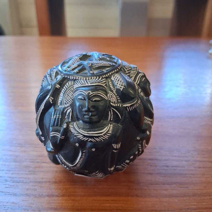 Decorative black stone figure on a wooden surface
