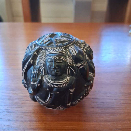 Decorative black stone figure on a wooden surface