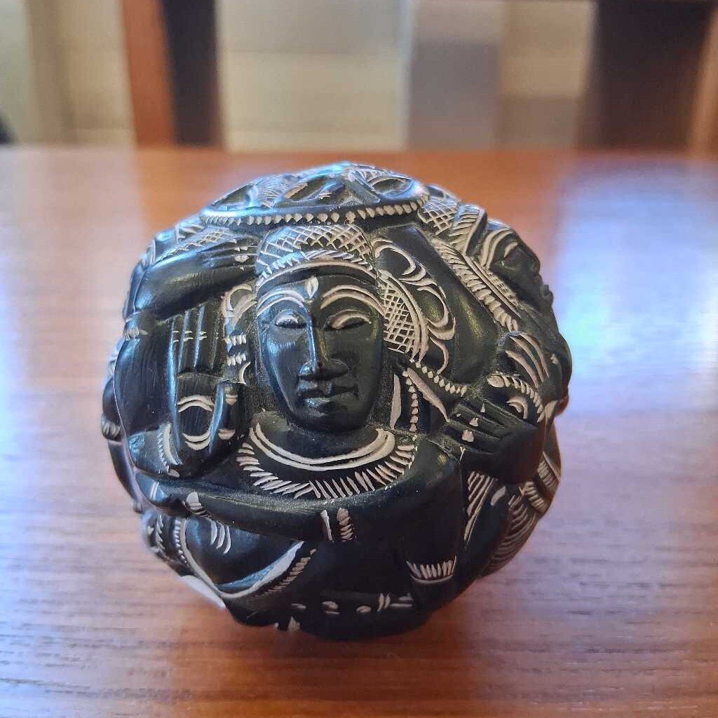 Decorative object with intricate carvings on a wooden surface