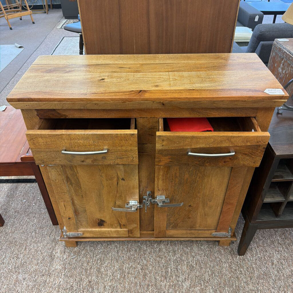 Wooden cabinet with two doors and a top shelf on a carpeted floor.