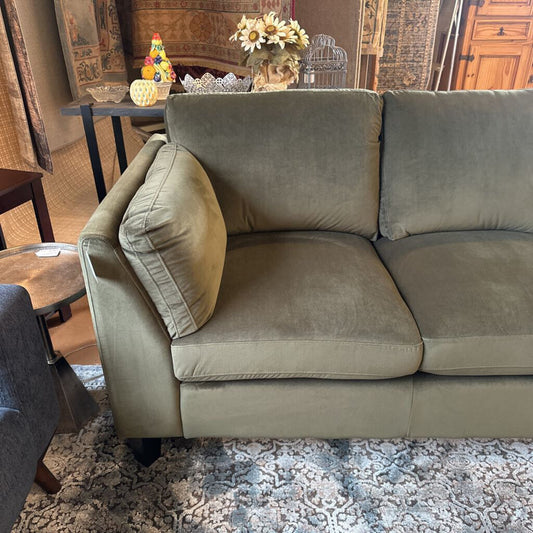 Gray sofa in a room with a table and decorative items.