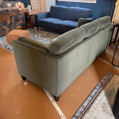 Gray sofa in a room with a blue wall and wooden floor.
