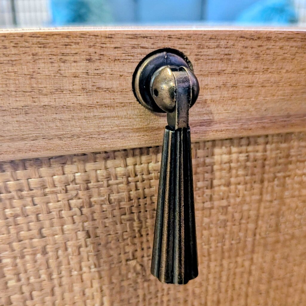 Brass handle on a woven wooden surface
