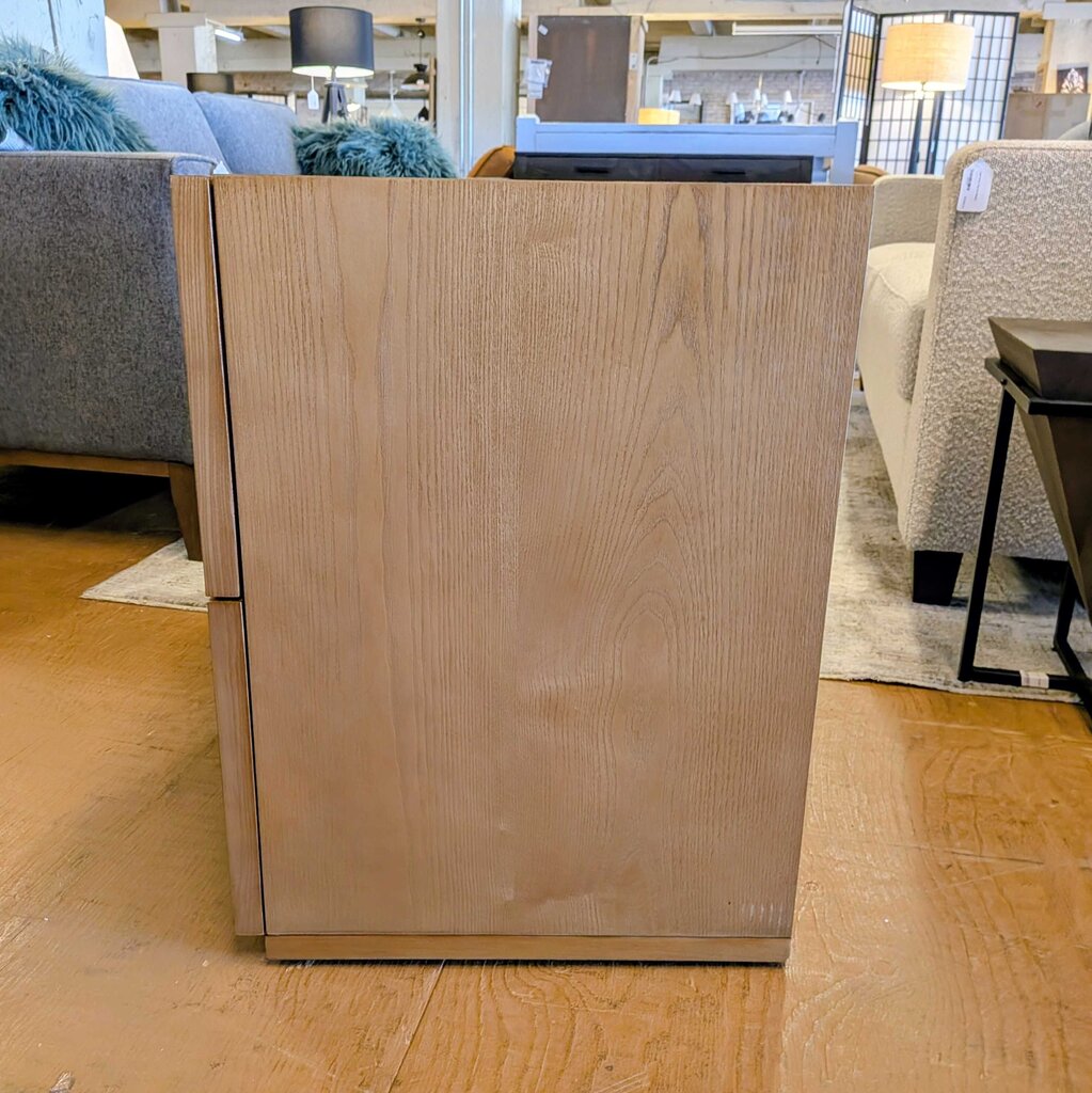 Wooden cabinet in a showroom setting with furniture and decor in the background