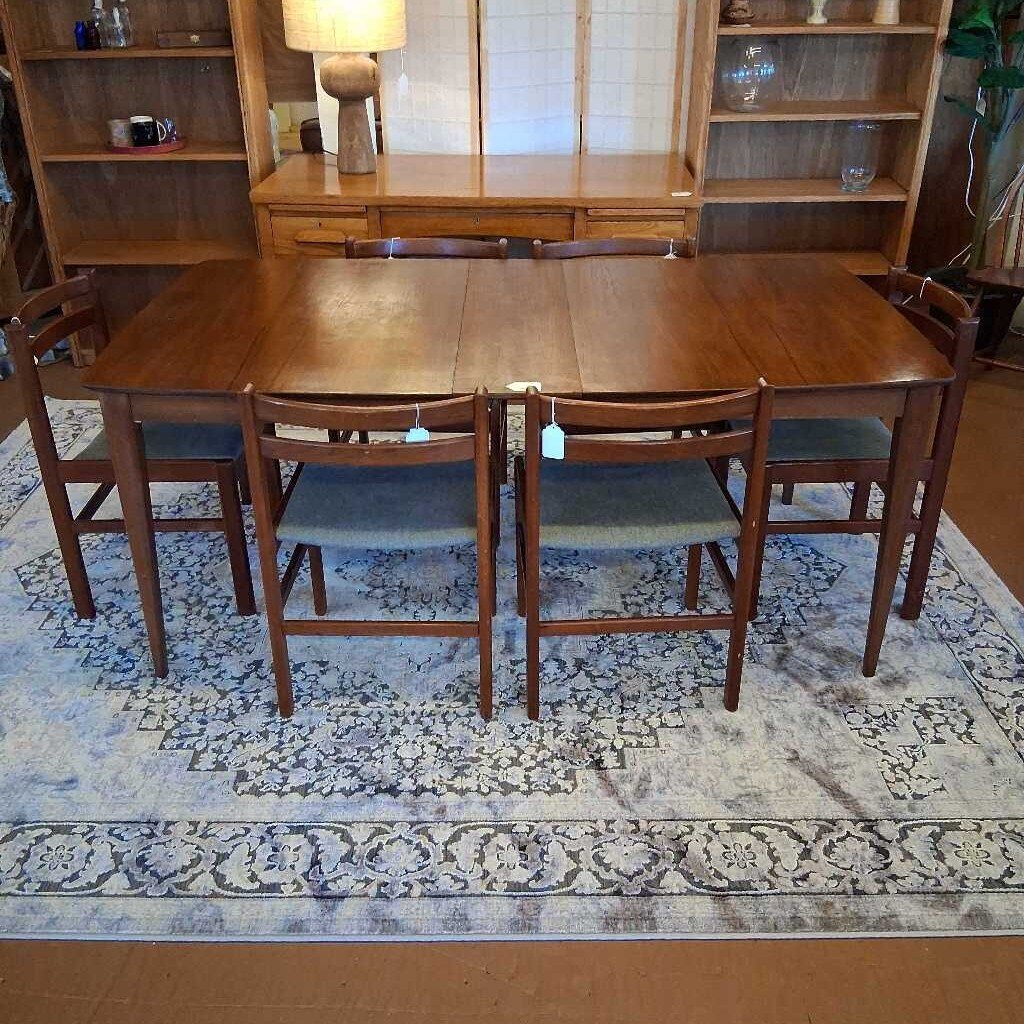 Wooden dining set with table and chairs on a patterned rug