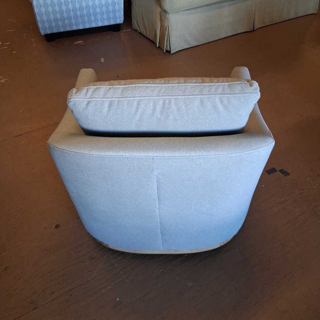 Light blue ottoman with a cushion on a wooden floor