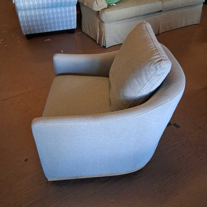 Beige armchair on a wooden floor with a blurred background