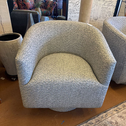Textured armchair in a room with a patterned rug and decorative elements.