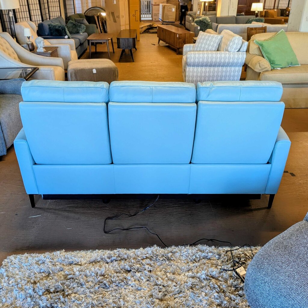 Blue sofa in a showroom with various furniture pieces in the background