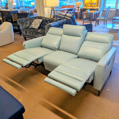Light gray sectional sofa in a showroom setting with other furniture.