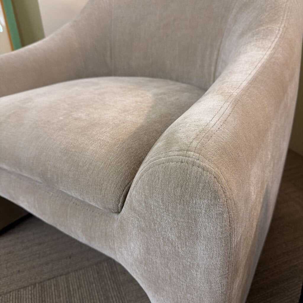 Close-up of a beige armchair with a soft texture.