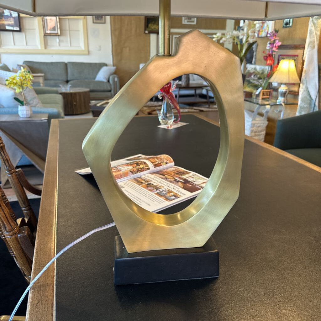 Decorative lamp with abstract design on a table in a room with furniture and decor.