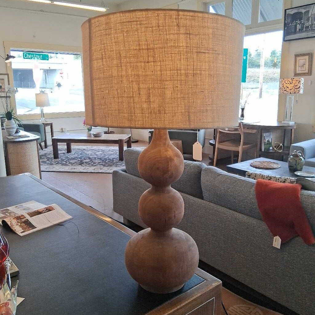 Decorative lamp with a textured shade on a table in a living room setting.